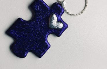 Purple puzzle piece in glass wiht silver heart detail