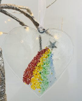 Fused glass heart hanger with rainbow decoration and copper star decoration and white trail detial.